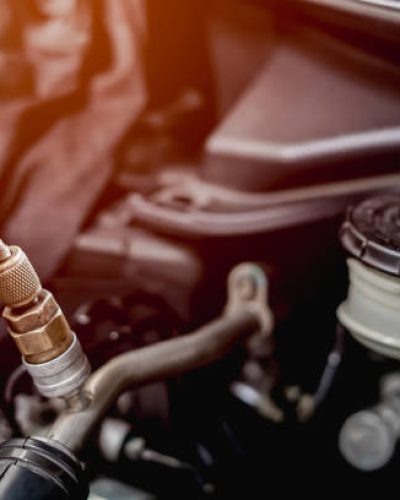 Old Car spark plug in a hand of Technician remove and change in engine room blur background service concept